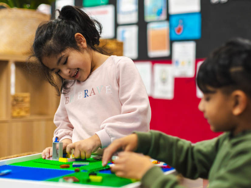 A girl and boy at outside school hours care playing lego together