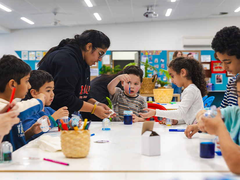 Teacher assisting kids with a fun activity